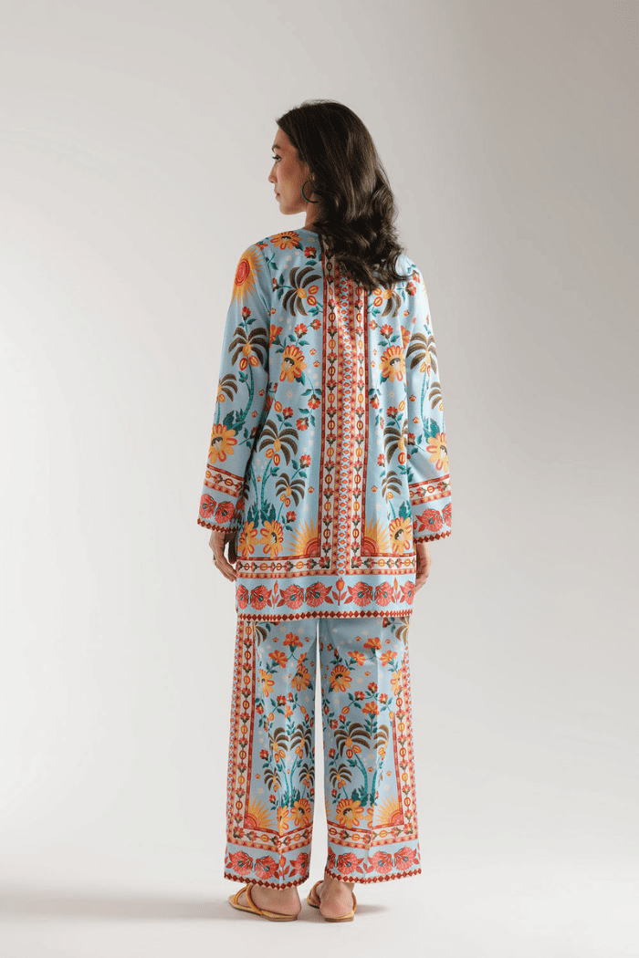 Woman wearing a colorful floral outfit on a plain background
