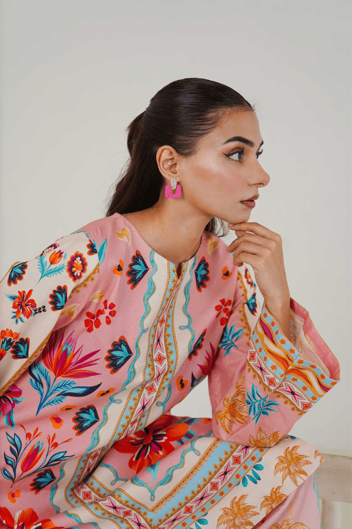 Woman wearing a colorful floral dress with a plain background