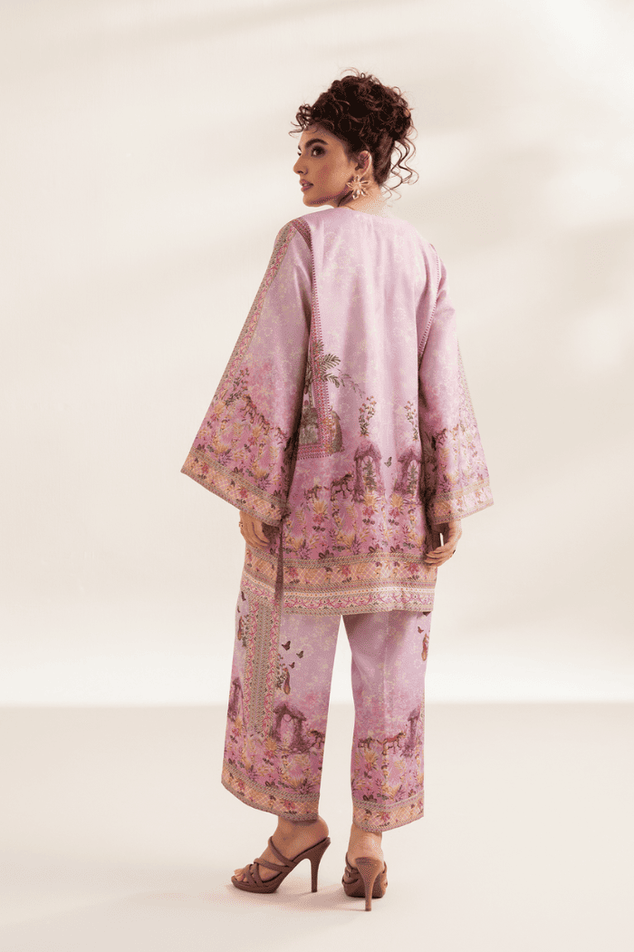 Woman wearing a pink embroidered outfit on a white background