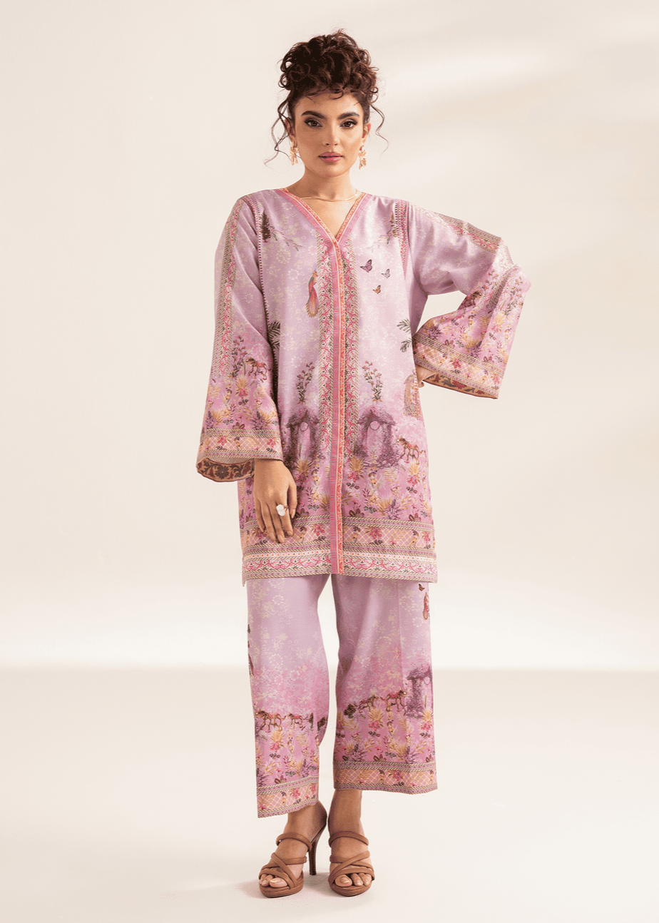 Woman wearing a pink embroidered outfit on a white background