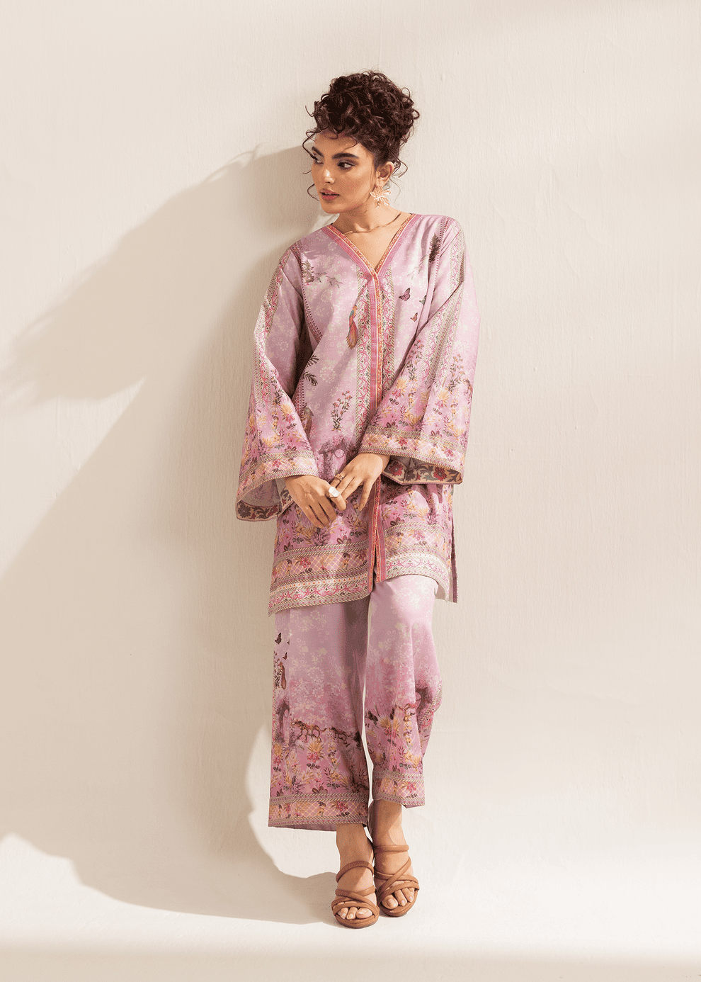 Woman wearing a pink floral outfit against a white background