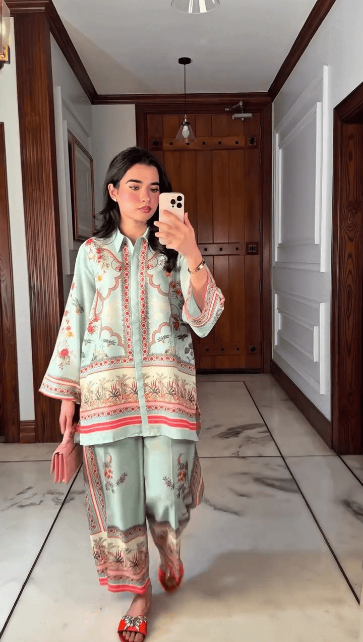 Woman taking a mirror selfie wearing a traditional outfit in a room with wooden paneling.