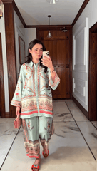 Woman taking a mirror selfie wearing a traditional outfit in a room with wooden paneling.