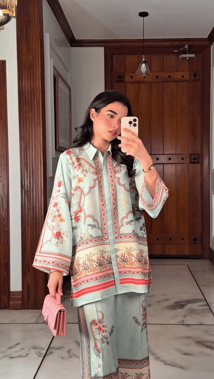Woman taking a mirror selfie wearing a traditional outfit in a room with wooden doors.