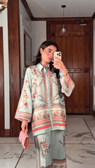 Woman taking a mirror selfie wearing a traditional outfit in a room with wooden doors.